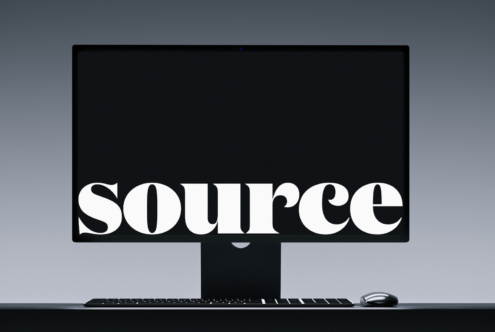 Desktop monitor with keyboard showing white serif typography on black screen