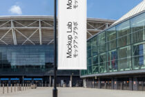 White fabric banner hanging on pole in front of modern building courtyard