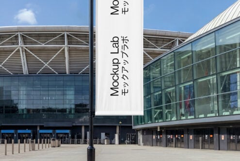 White fabric banner hanging on pole in front of modern building courtyard