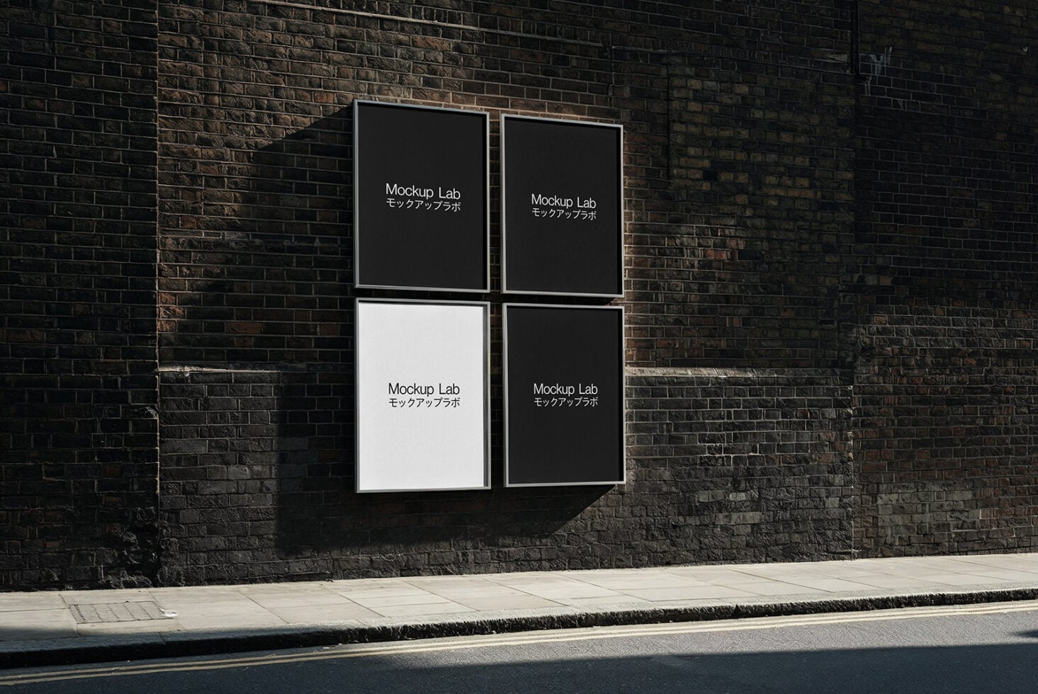 Four frame grid mounted on dark brick wall with poster layouts