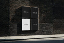 Four frame grid mounted on dark brick wall with poster layouts