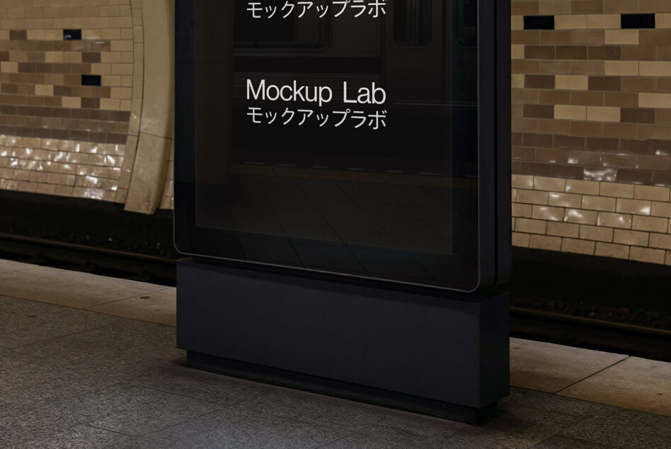 Tall dark screen in brick corridor displaying Mockup Lab branding