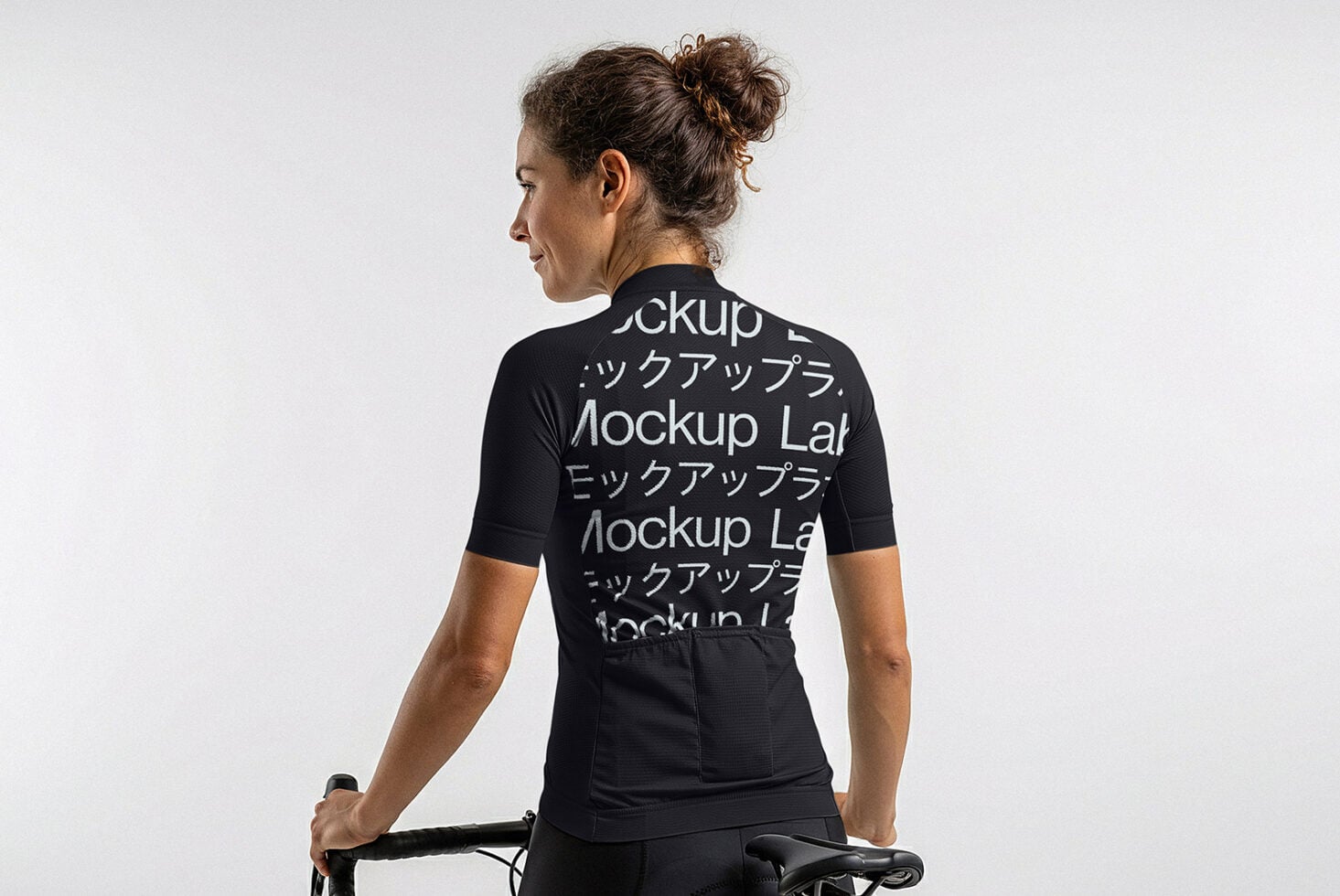 Woman on bike wearing black cycling jersey mockup rear view