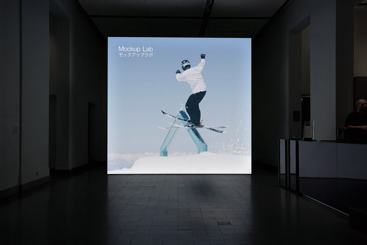Indoor exhibition displaying skier mid-jump on illuminated wall screen