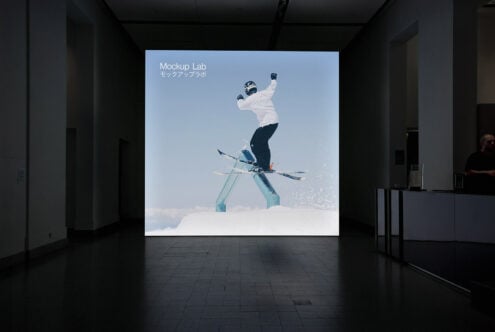 Indoor exhibition displaying skier mid-jump on illuminated wall screen