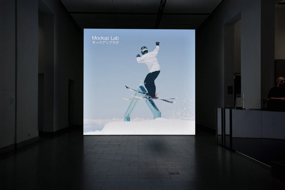 Indoor exhibition displaying skier mid-jump on illuminated wall screen
