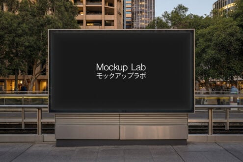 Black digital billboard in public plaza surrounded by city buildings trees
