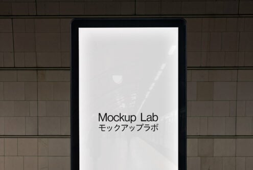 Black tablet on brick wall showing white screen with Mockup Lab text