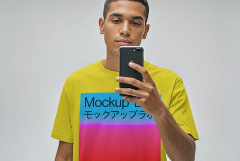 Guy in neon yellow tee holding black phone, colorful gradient print on chest