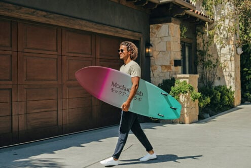 Guy holding gradient pink to mint surfboard mockup outdoors