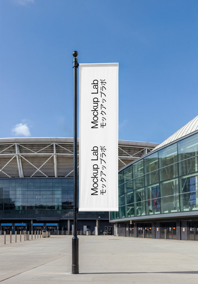 Vertical pole flag with white background under blue sky near architecture