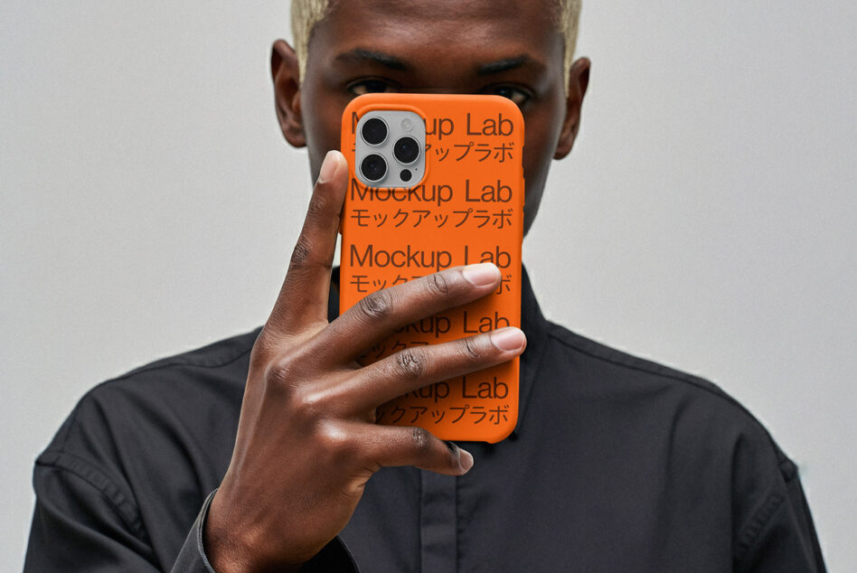 iPhone 12 Pro case mockup in vibrant orange held up covering person's face in black shirt