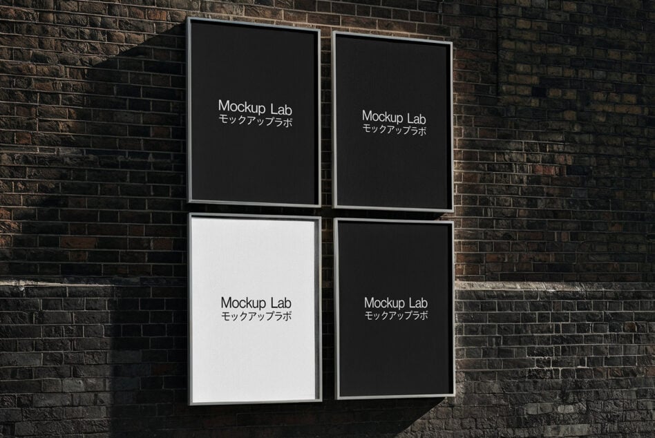 Four framed posters on brick wall with mixed black, white, grey backgrounds