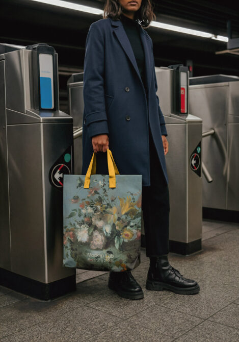 Woman in subway holding tote bag with floral botanical print design