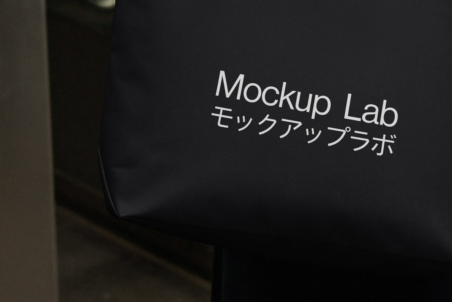 Close up of black tote bag with white Mockup Lab bilingual branding