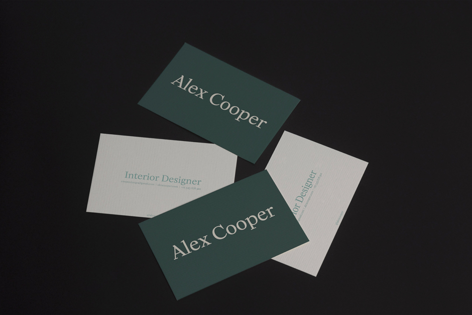 Four business cards fanned out showing teal, cream, sides with Interior Designer text