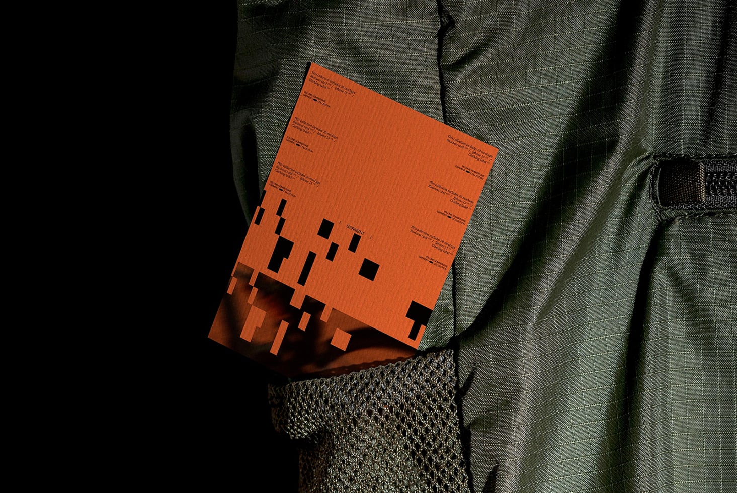 Bright orange clothing label mockup with black geometric shapes, shot flat lay on textured fabric