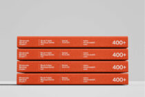 Stack of four red book folders with rounded edges on neutral gray background