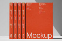 Four red books lined up beside large red book mockup with neutral backdrop