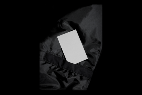 Blank business card on black fabric surface mockup. Ideal for showcasing branding designs and templates. High-contrast minimalist style.