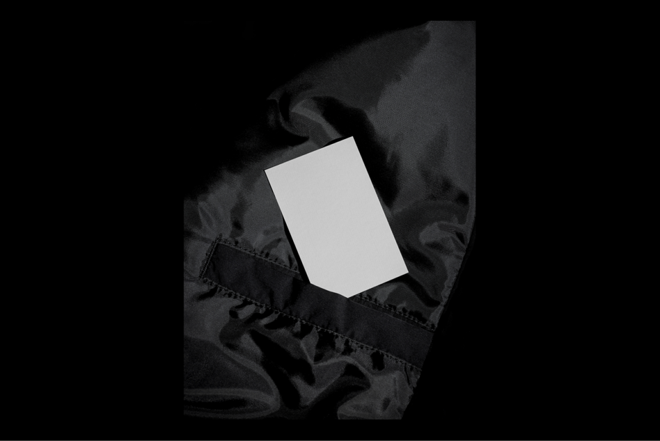 Blank business card on black fabric surface mockup. Ideal for showcasing branding designs and templates. High-contrast minimalist style.
