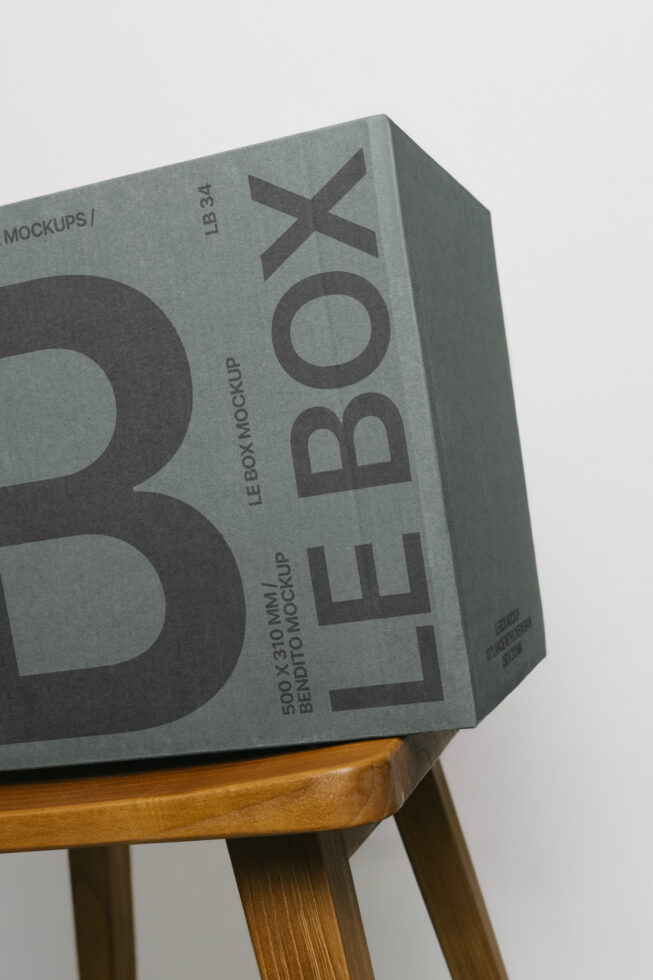 Tall box mockup with bold sans serif typography on wooden stool