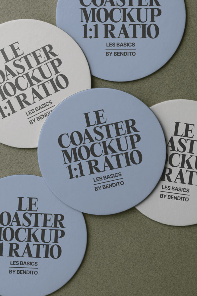 Round coasters in blue, cream with printed text scattered on green surface