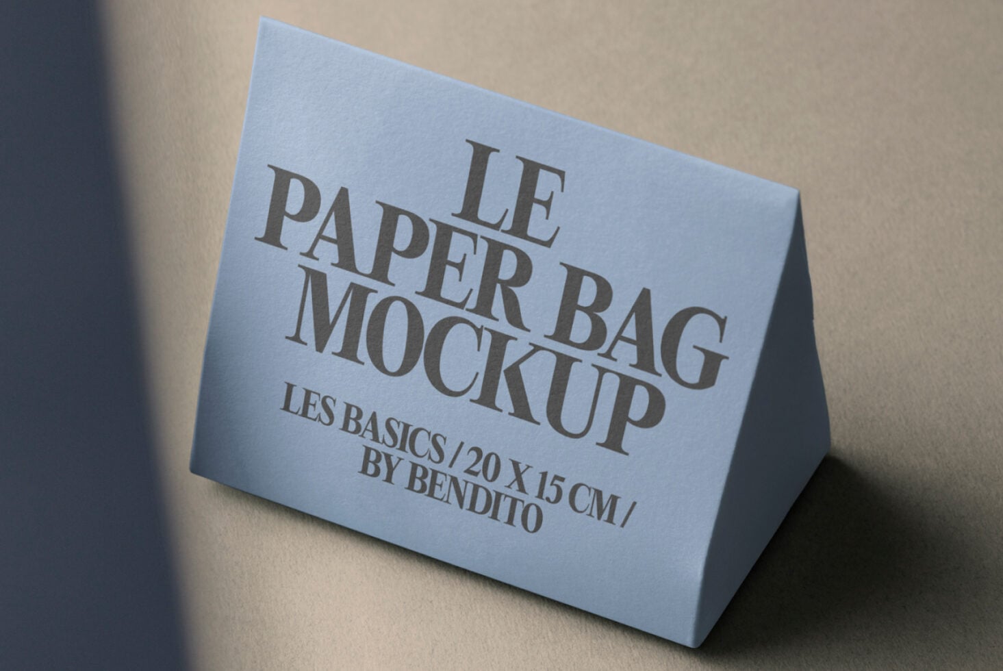 Blue paper bag tent mockup on neutral background with warm side lighting
