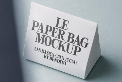 White paper bag mockup positioned on soft blue-grey surface with shadows