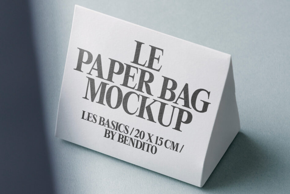 White paper bag mockup positioned on soft blue-grey surface with shadows