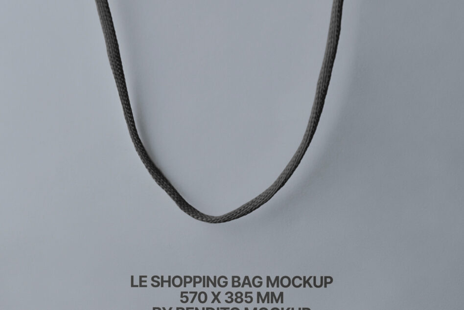 Overhead view of black fabric handles forming U-shape on blue-grey surface