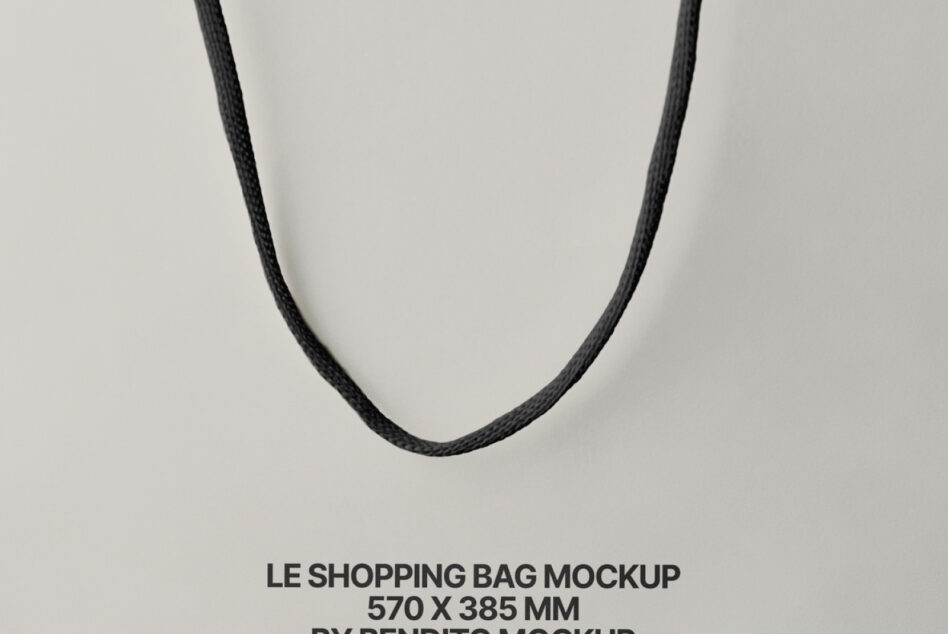 Minimalist shot of dark twisted rope handles suspended against neutral beige