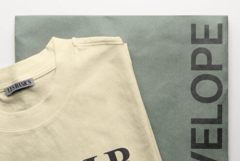 Cream t-shirt with woven label folded on sage green cardboard