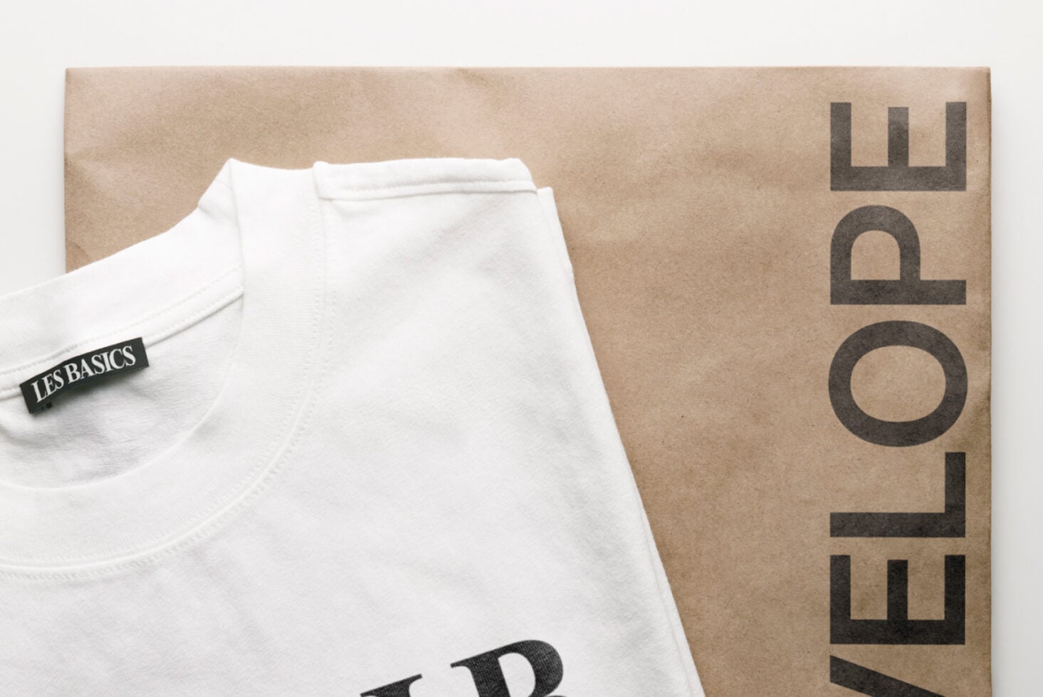 Folded white tee with LB branding next to kraft paper packaging
