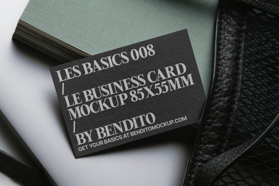Dark card mockup on sage green paper stack with black leather accessory styling