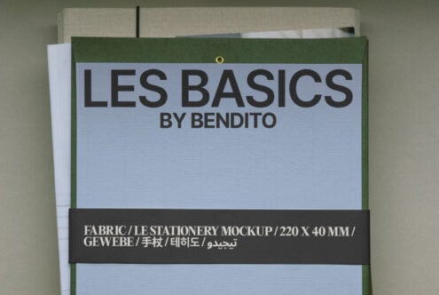 Fabric label mockup flat lay showing light blue panel, dark text band