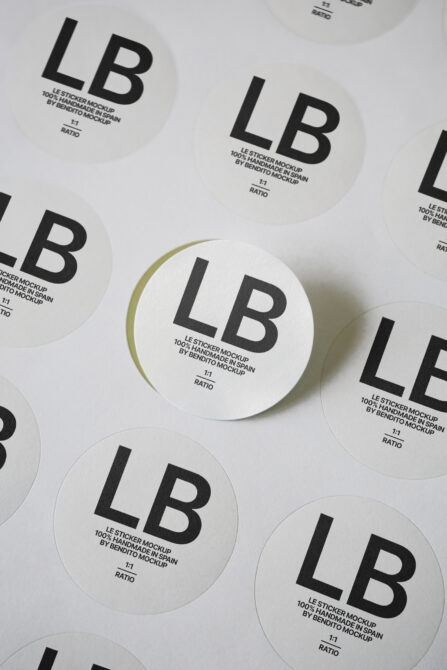 White circular stickers with bold LB initials arranged in flat lay composition