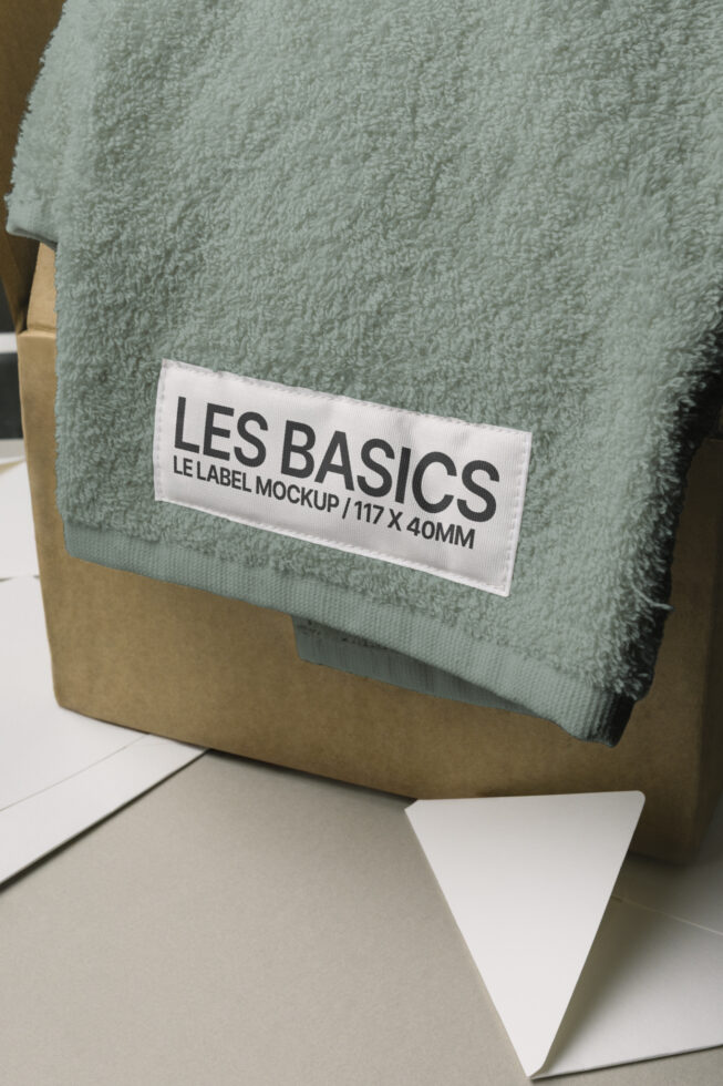 Soft green folded towel with white label mockup on kraft box, open notebook visible