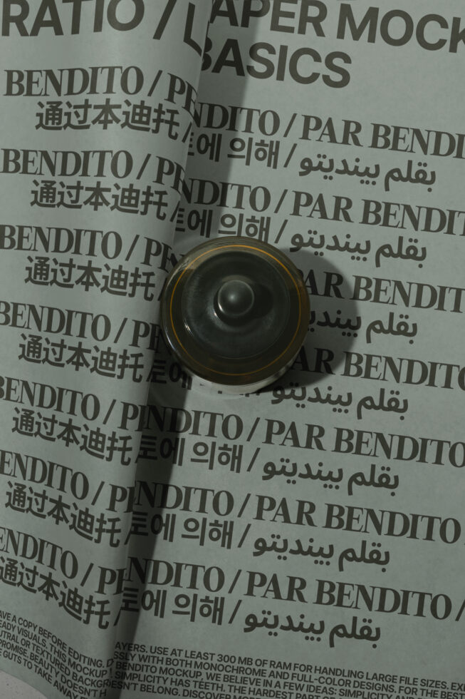 Rolled paper mockup with multilingual text on crumpled background, gold-rimmed black speaker on top