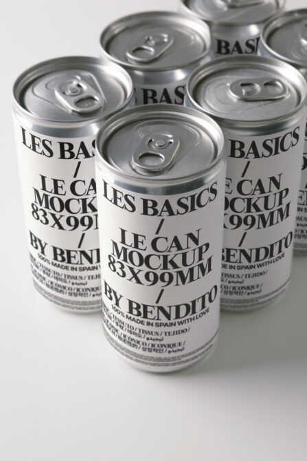 Close up of three beverage cans with pull ring tops, cream colored labels, black text overlay