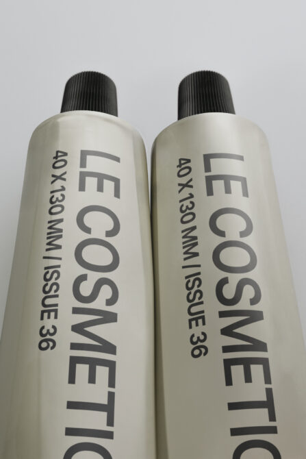 Pair of cream colored cosmetic spray bottles with black ribbed pump tops