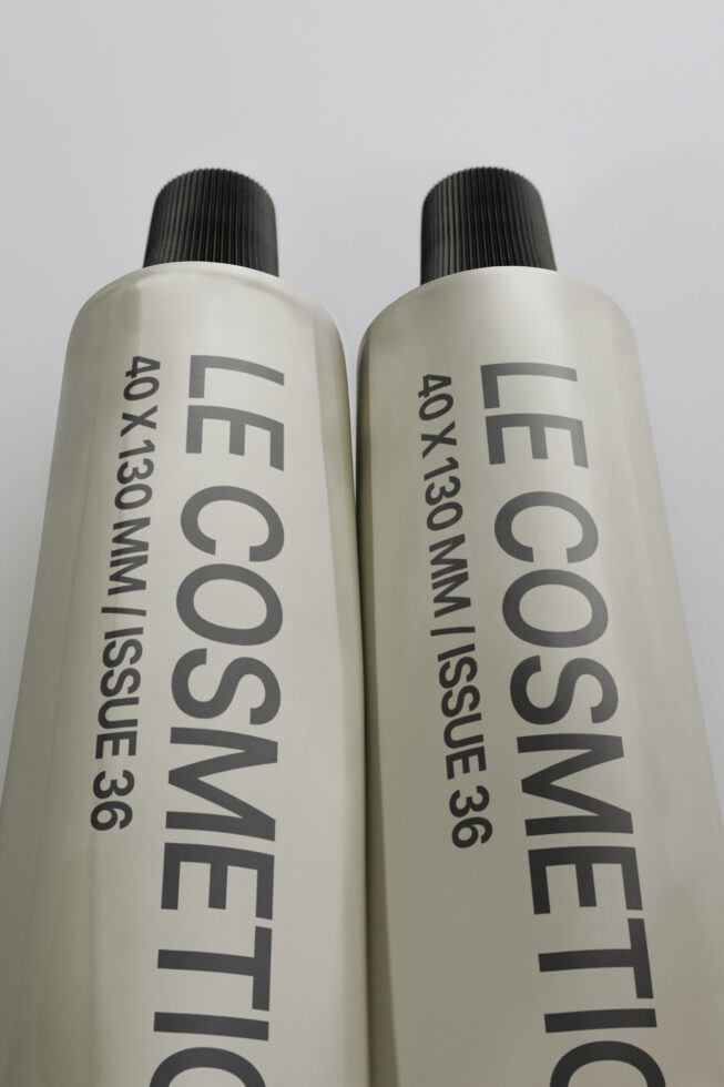Pair of cream colored cosmetic spray bottles with black ribbed pump tops