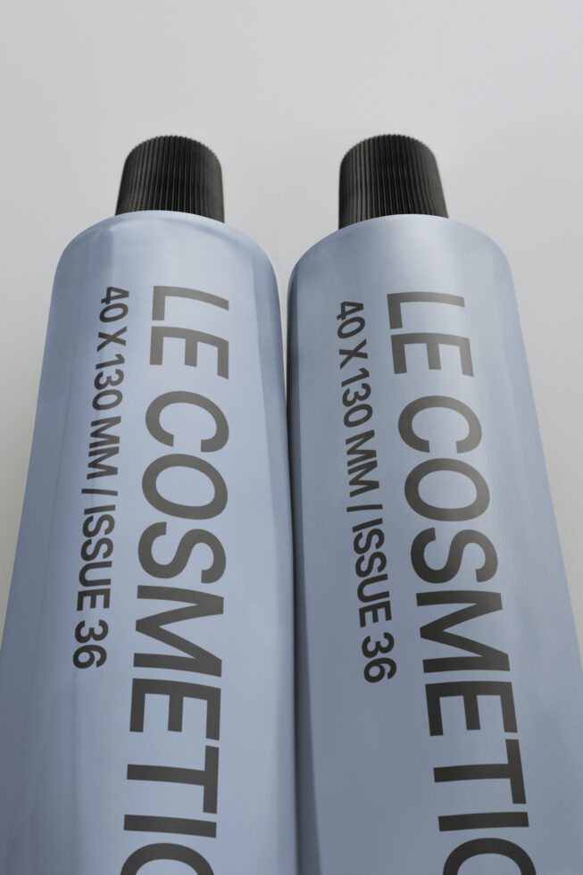 Two tall cosmetic spray bottles in light blue with black ribbed caps