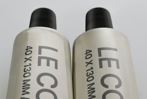 Two off white cosmetic bottles with black pump dispensers side by side