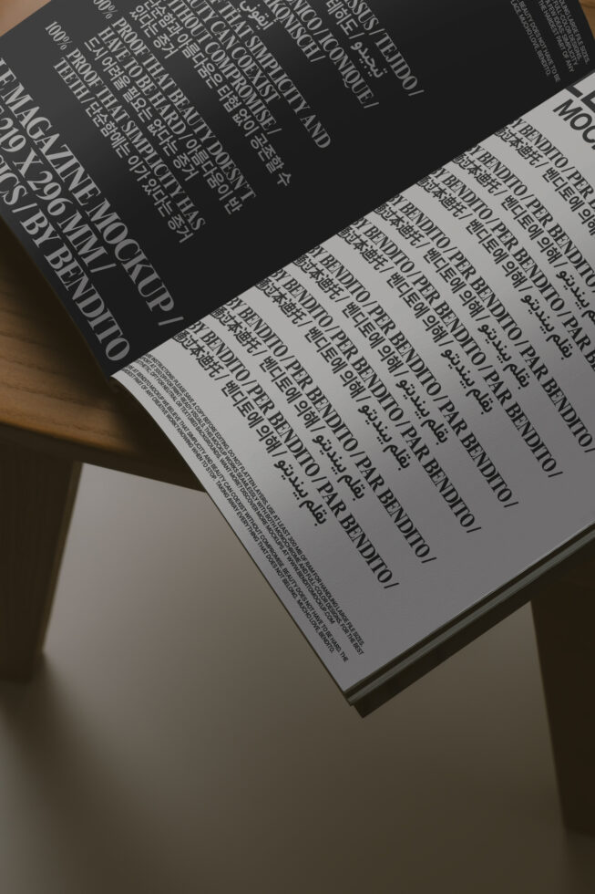 Open magazine spread showing black pages with repeated text on warm wood