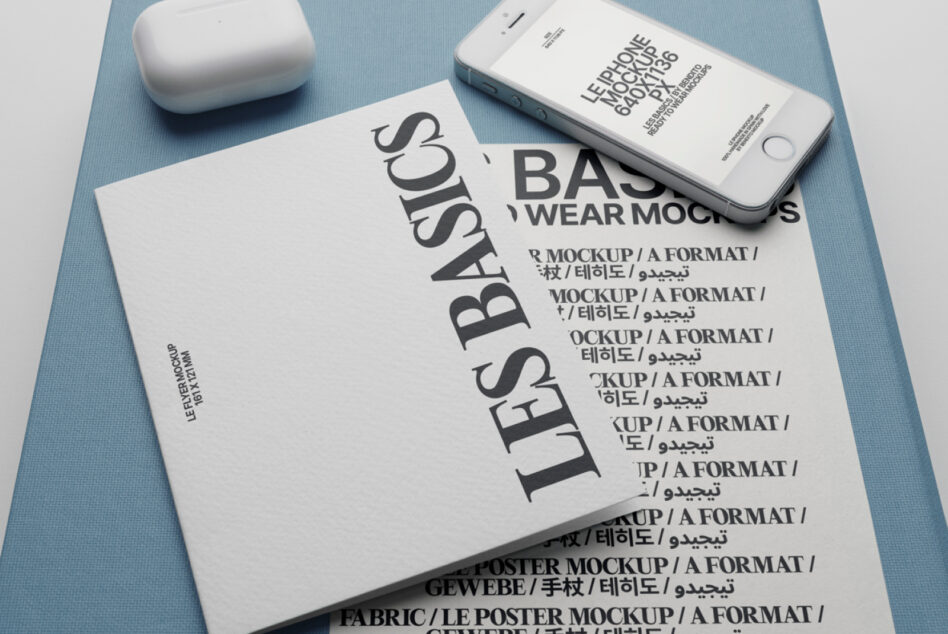 Flat lay of poster, phone, wireless earbuds on soft blue background