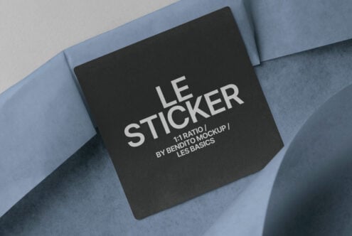 Dark sticker mockup with Les Basics branding on curved blue fabric backdrop