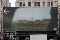 Urban billboard mockup showing mountain landscape between skyscrapers