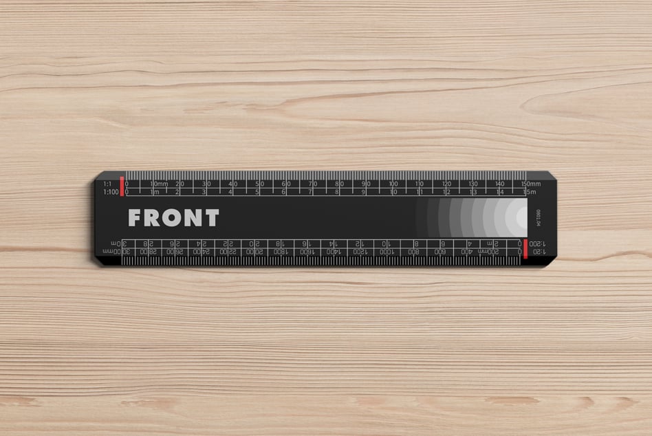Black scale ruler with white markings on light wooden surface flat lay
