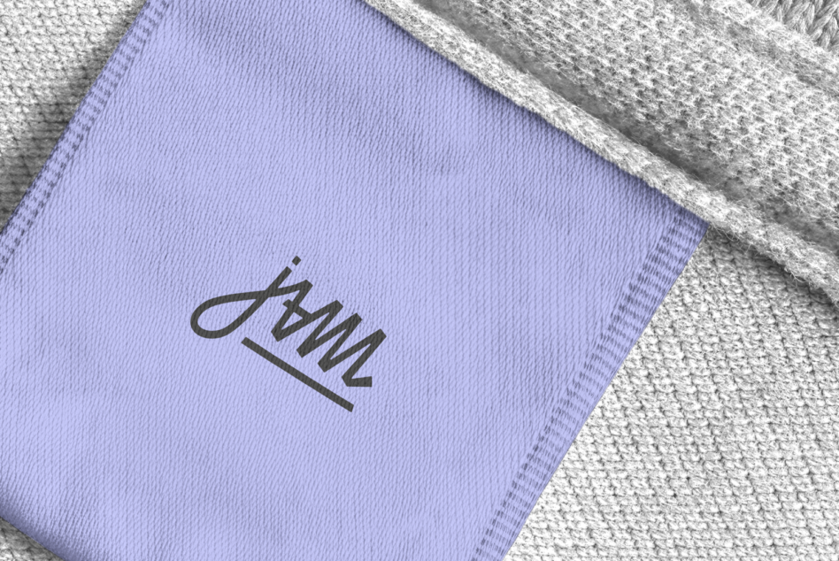 Lavender fabric tag mockup with handwritten script logo on textured textile